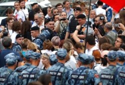 FILE - Police officers block supporters of Russian investigative journalist Ivan Golunov during a march in Moscow, June 12, 2019.