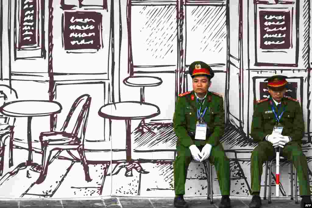 Vietnamese policemen sit on stools near the Sofitel Legend Metropole hotel in Hanoi ahead of the second U.S.-North Korea summit.
