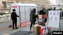 北京一個住宅小區的入口設立消毒棚和登記處。（2020年2月13日）