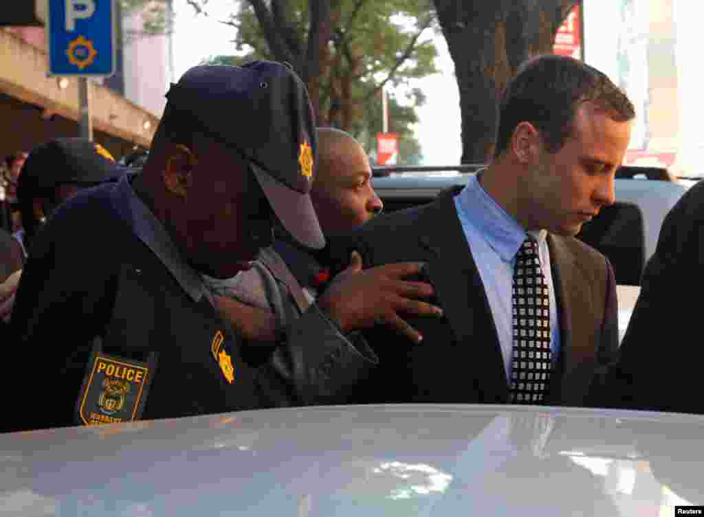 Oscar Pistorius leaves the Pretoria Magistrates court after a brief appearance, June 4, 2013.