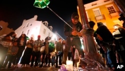 Un amigo de la víctima mortal del tiroteo en Bourbon Street coloca un globo en el memorial improvisado.