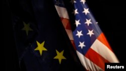 An EU flag and an U.S. flag are pictured in front of the German Finance Ministry before a meeting between German Finance Minister Wolfgang Schaeuble and U.S.Treasury Secretary Timothy Geithner in Berlin December 6, 2011. REUTERS/Tobias Schwarz (GERMANY - 