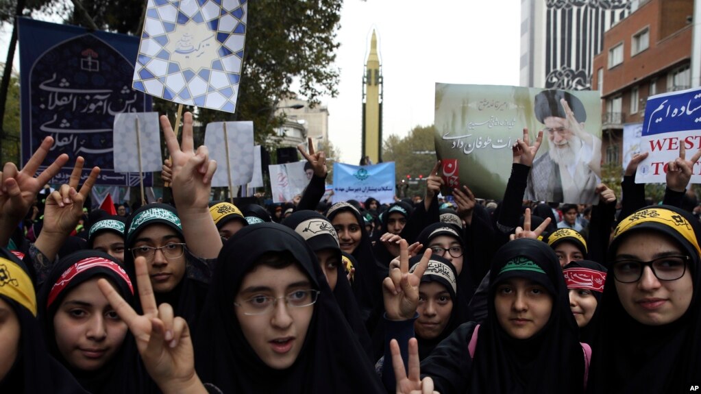 Niñas estudiantes iraníes hace el signo de la victoria en una manifestación anual frente a la excede de la embajada de EE.UU. en Teherán, en el aniversario de la toma de la sede diplomática el sábado, 4 de noviembre de 2017.
