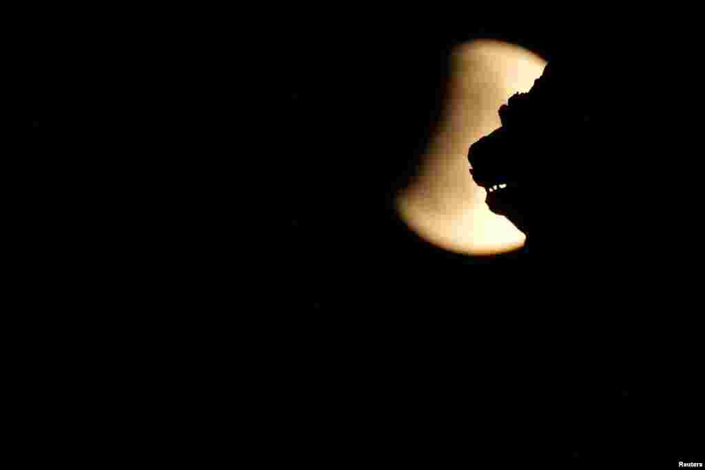 سینٹ مارک اسکوائر وینس میں جُزوی چاند گرہن کا ایک نظارہ۔ یورپ میں چاند گرہن غروب آفتاب کے بعد شروع ہوا جبکہ آسٹریلیا میں بدھ کی صبح سے کچھ دیر قبل دیکھا گیا۔