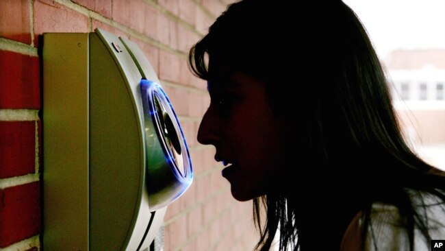 FILE - A woman uses an iris scanner to enter an elementary school in Freehold, N.J. Those who choose to register with the system can use the iris-scanning camera to unlock doors automatically. The African region of Somaliland has become the first to use such a biometric system to identify voters and prevent duplicate voting.