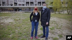 In this image provided by Budapest City Hall, Gergely Karacsony, Mayor of Budapest, right, and Krisztina Baranyi, the mayor of Budapest's 9th district, left, pose together for a photo at the planned site of the Chinese Fudan University campus in Budapest,