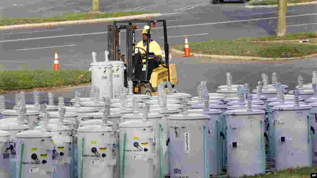 PSE&G employee Percy Thompson III unloads new electrical transformers in a parking lot used as a staging area at the Quaker Bridge Mall, November 1, 2012, in Lawrence Township, N.J.