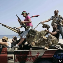 Rebel fighters search for Libyan leader Moammar Gadhafi's forces in Tripoli, August 26, 2011