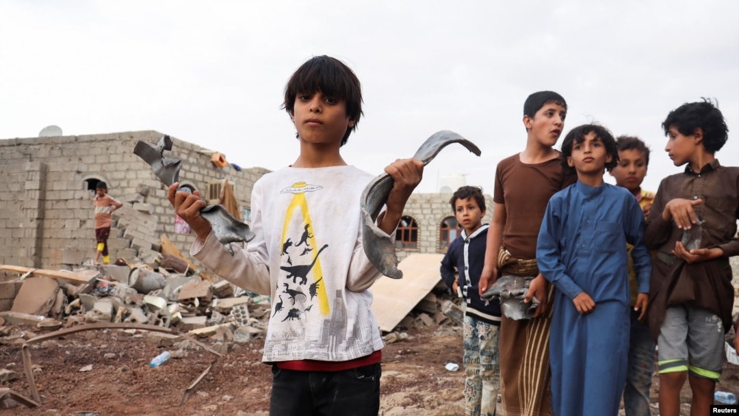 Seorang anak laki-laki tampak memegang pecahan peluru meriam dari rudal di lokasi serang yang diluncurkan oleh kelompok pemberontak Houthi di Marib, Yaman, pada 3 Oktober 2021. (Foto: Reuters/Ali Owidha)