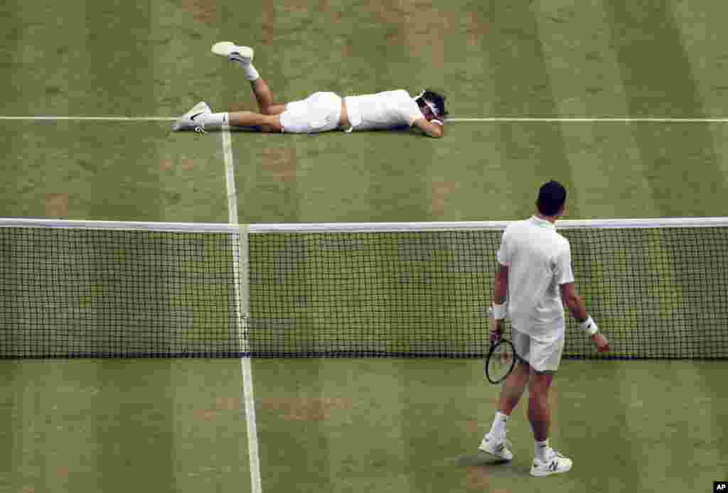 Roger Federer of Switzerland, top, falls over during his men&#39;s semifinal singles match against Milos Raonic of Canada on day 12 of the Wimbledon Tennis Championships in London. Federer ended up losing the match.