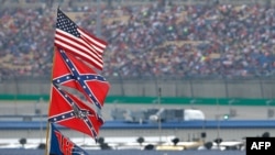 FILE - American and Confederate flags fly over the infield during the NASCAR Sprint Cup Series Quaker State 400 in Sparta, Kentucky, July 11, 2015.