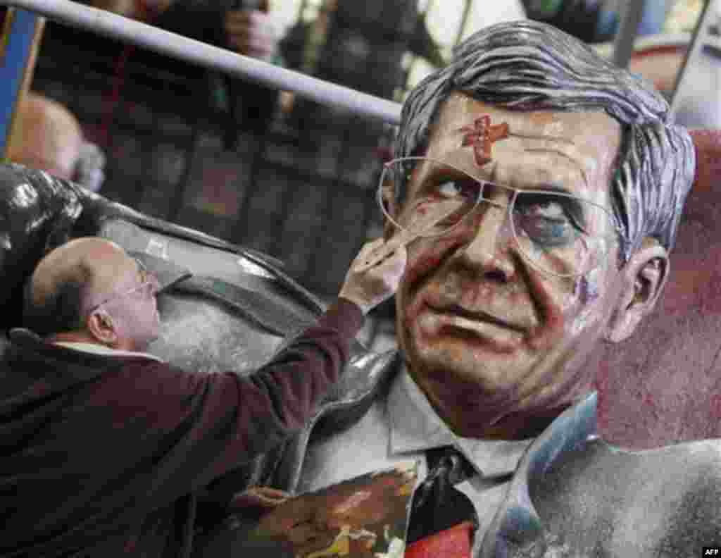 Dieter Wenger of the carnival club of Mainz works on the face of a paper machee figure depicting German President Christian Wulff in a garage in Mainz, Germany, Friday, Feb. 17, 2012. Wulff resigned from his post on Friday. (AP Photo/Michael Probst)