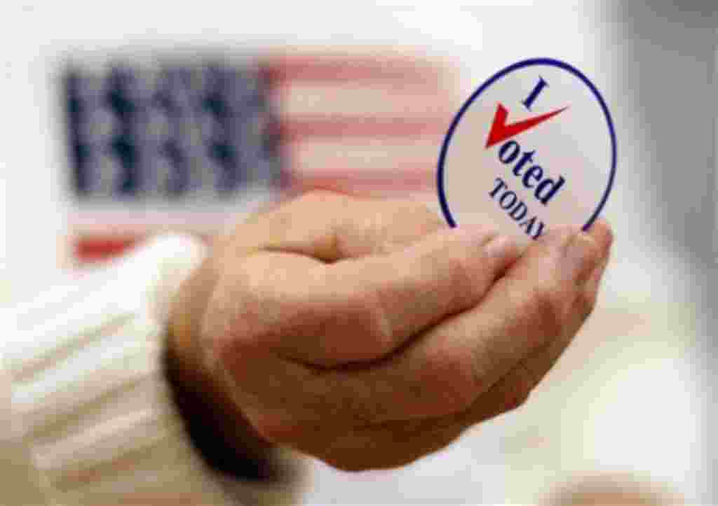 A sticker is handed to a voter on Election Day in Waterville, Maine, 02 Nov 2010