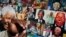 A well-wisher uses his phone to take a picture of a banner of photos of Nelson Mandela, outside the Mediclinic Heart Hospital in Pretoria, July 18, 2013. 