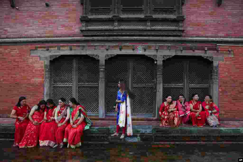Hindu women take a break at the Pashupatinath temple during Teej festival celebrations in Kathmandu, Nepal.