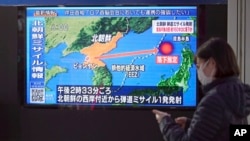 Žena prolazi pored TV-a koji emituje vijest o lansiranju projektila Sjeverne Koreje u četvrtak, 24. marta 2022., Tokio, Japan.