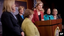 Sen. Elizabeth Warren, D-Mass., center, accompanied by fellow Democratic Women Senators, speaks during a news conference on Capitol Hill in Washington, Jan. 30, 2014, to show their support on raising the federal minimum wage.