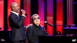 In this Oct. 8, 2018, photo, host Darius Rucker, left, introduces Ronnie Milsap during "An Opry Salute to Ray Charles" at the Grand Ole Opry House in Nashville, Tenn. 