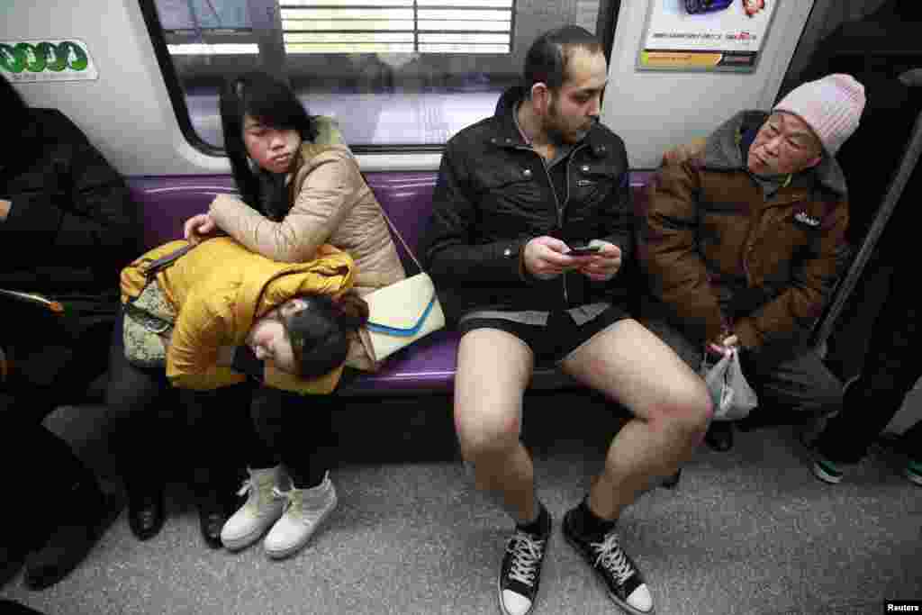 Passengers look at a man not wearing pants, while riding in the subway during the annual &#39;No Pants Subway Ride&#39; in Shanghai, China.