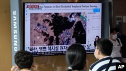 People watch a TV screen showing a file satellite image of the Yongbyon nuclear site in North Korea during a news program at the Seoul Railway Station in Seoul, South Korea, Aug. 30, 2021. 