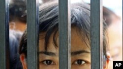 Family members of prisoners wait for their release in front of the Insein Prison gate in Yangon. Myanmar's new government began freeing about 14,000 prisoners and commuting thousands more sentences on Tuesday in an amnesty critics dismissed as a token ges