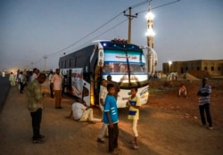 Orang-orang bersiap melanjutkan perjalanan mereka dengan bus, setelah salat Maghrib dan berbuka puasa Ramadan di sepanjang sisi jalan raya Negara Bagian Jazeera di desa al-Nuba, sekitar 50 kilometer selatan ibu kota Sudan, 22 April 2021. (AFP)