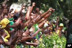 FILE: Supporters of Zimbabwean President Robert Mugabe cheer upon his arrival for the opening of the first session of the eighth Parliament of Zimbabwe in Harare, Sept. 17, 2013.