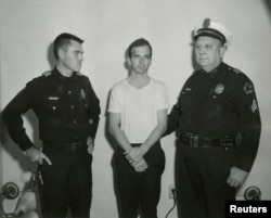 FILE - Lee Harvey Oswald, accused of assassinating U.S. President John F. Kennedy, is pictured with a Dallas police sergeant and an officer in this handout image taken Nov. 22, 1963.