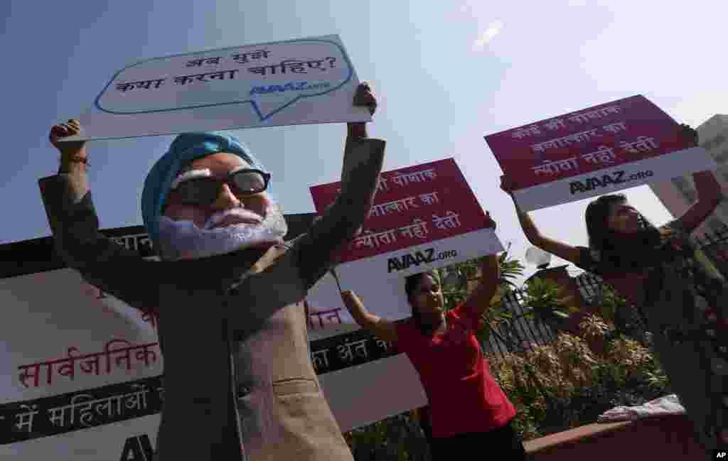 A man wearing a mask of Indian Prime Minister Manmohan Singh participates in a protest along with women outside the court where the accused in the gang rape will be tried, in New Delhi, India, January 21, 2013.