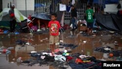 A migrant boy, part of a caravan of thousands from Central America trying to reach the United States, stands in a temporary shelter after heavy rainfall in Tijuana, Mexico, Nov. 29, 2018. The IOM says it has helped hundreds of migrants from the caravan return home.