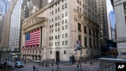 A giant American Flag hangs on the New York Stock Exchange, Sept. 21, 2020. Stocks fell on Wall Street, joining a global tumble for markets. 
