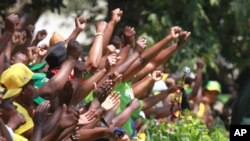 Supporters of Zimbabwean President Robert Mugabe cheering him recently outside parliament.