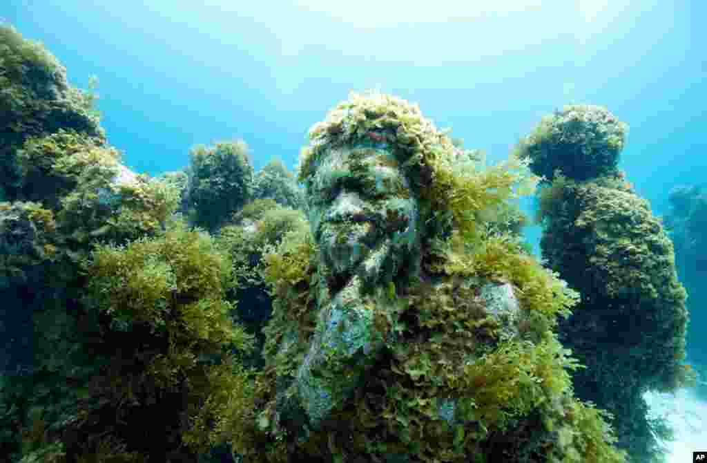 British artist Jason deCarires Taylor’s life-sized sculptures in an underwater park in Cancun become a new reef under the sea. (Photo: McNicholas/Creswell)