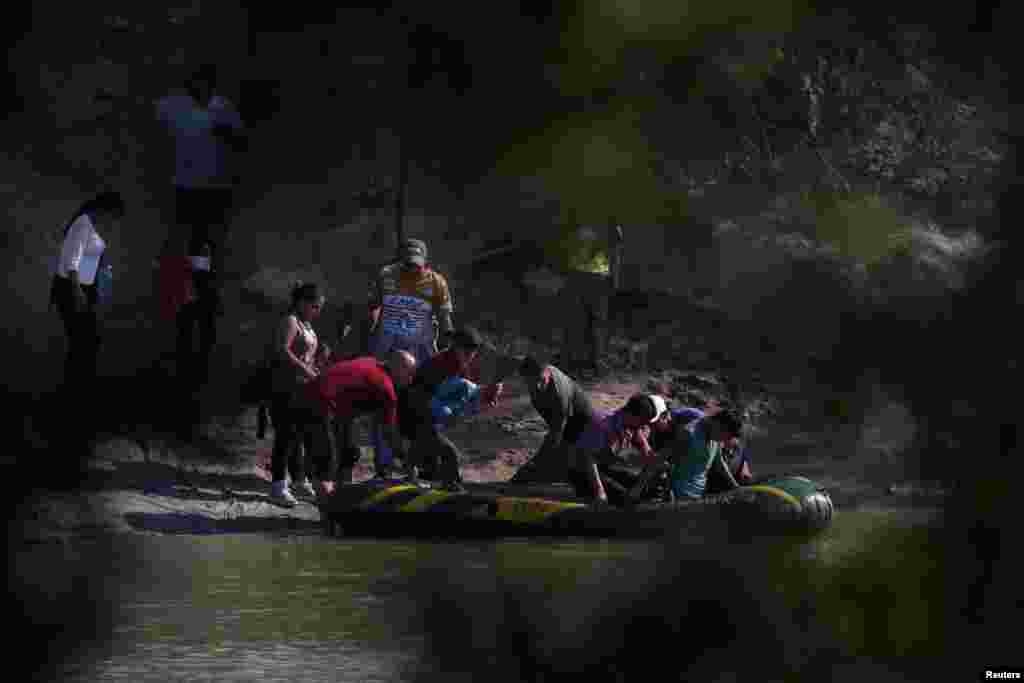 Suspected smugglers load men, women and children into a raft on the Mexican side of the Rio Grande just before illegally crossing the Mexico-U.S. border near McAllen, Texas, May 9, 2018.