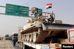 FILE - A convoy of Iraqi security forces advances on the outskirts of Mosul, Oct. 12, 2016, to fight against Islamic State militants.