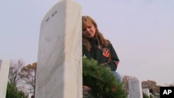 Ilka Halliday places a Christmas wreath at the grave of her son, Christopher Wilson, at Arlington National Cemetery