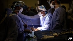 Dr. Sunil Singhal, center, directs a special camera to look at a patient's tumor, made visible with a glowing dye at the Hospital of the University of Pennsylvania in Philadelphia, January 23, 2018. (AP Photo/Matt Rourke)