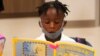 Kindergarten student Taiden Watkins reads a book, Aug. 10, 2021, during the first day of school at Washington Elementary School in Riviera Beach, Fla.