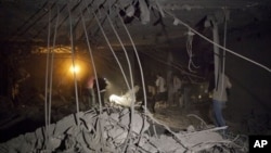 In this photo taken on a government organized tour, officials and members of the media inspect the ruins of a house Libya says was the site of a NATO missile attack in Tripoli, Saturday, April 30, 2011.