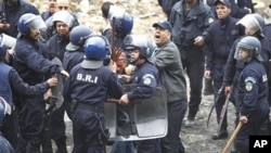 Riot policemen detain a protester during a demonstration in Oued Koriche, Algiers, March 23, 2011