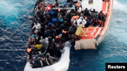 FILE - An image taken from video shot on Jan. 27, 2017 by the Italian Coast Guard shows migrants being rescued from members of Italian Coast Guard vessel Diciotti in the central Mediterranean sea.
