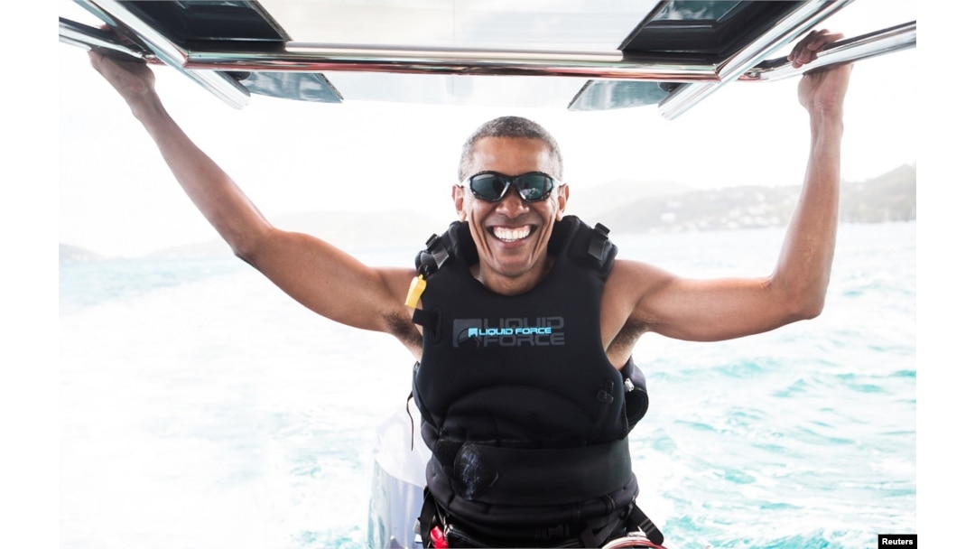 Former U.S. President Barack Obama sits on a boat during a kite surfing outing with British businessman Richard Branson during his holiday on Branson's Moskito island, in the British Virgin Islands, in a picture handed out by Virgin, Feb, 7, 2017.