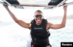 Former U.S. President Barack Obama sits on a boat during a kite surfing outing with British businessman Richard Branson during his holiday on Branson's Moskito island, in the British Virgin Islands, in a picture handed out by Virgin, Feb, 7, 2017.