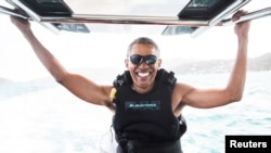 Mantan presiden AS Barack Obama duduk di atas perahu untuk melakukan 'kiteboarding' dengan miliarder Richard Branson di Pulau Moskito, Kepulauan Virgin (7/2). 