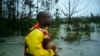 Seorang relawan mencari pemilik seekor anjing yang diselamatkannya dari banjir akibat hantaman badai Dorian di Freeport, Grand Bahama, 3 September 2019.