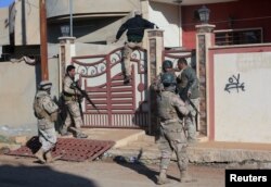 FILE - Iraqi army soldiers search a house for Islamic State militants and improvised explosive devices (IEDs) north of Mosul, Iraq, Jan. 19, 2017.