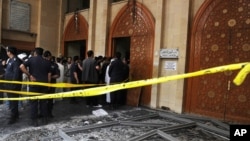 Security forces and officials gather at a Shiite mosque after a deadly blast claimed by the Islamic State group that struck worshipers attending Friday prayers in Kuwait City, June 26, 2015. 