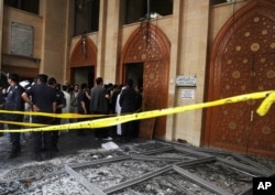 FILE - Security forces and officials gather at a Shi'ite mosque after a deadly blast claimed by the Islamic State group that struck worshipers attending Friday prayers in Kuwait City, June 26, 2015.