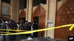 Security forces and officials gather at a Shiite mosque after a deadly blast claimed by the Islamic State group that struck worshipers attending Friday prayers in Kuwait City, June 26, 2015. 