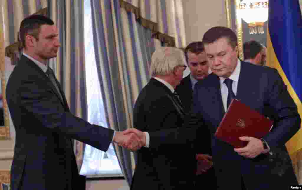 Tổng thống Ukraina Viktor Yanukovych (phải) bắt tay lãnh đạo đối lập Vitaly Klitschko sau khi ký một thỏa thuận hòa bình do Liên minh châu Âu làm trung gian điều giải nhằm chấm dứt những vụ đối đầu bạo động khiến hàng chục người chết và mở đường cho một cuộc bầu cử tổng thống trước thời hạn vào năm nay tại dinh tổng thống ở Kyiv.